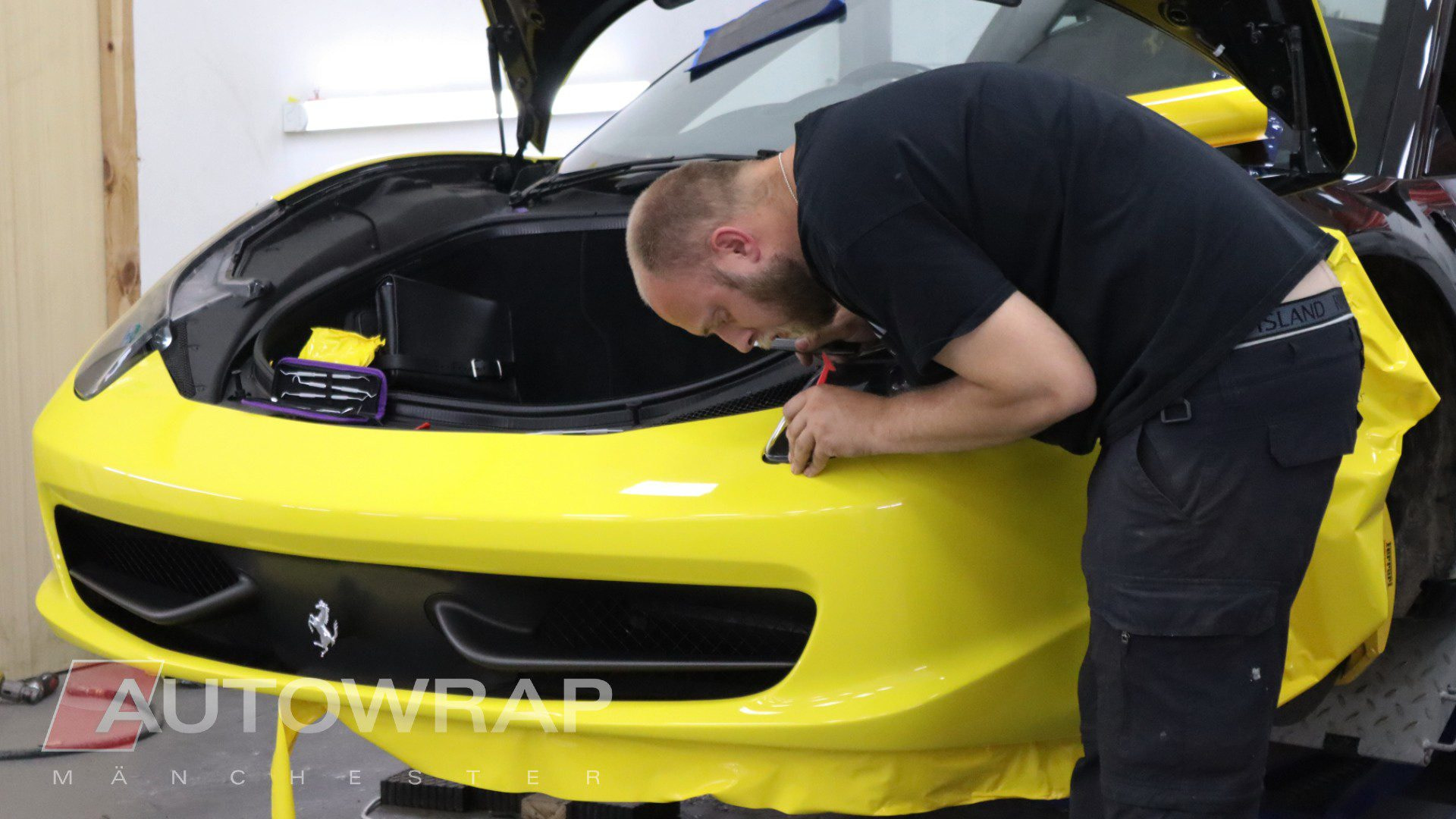 a wrapper working on a yellow car