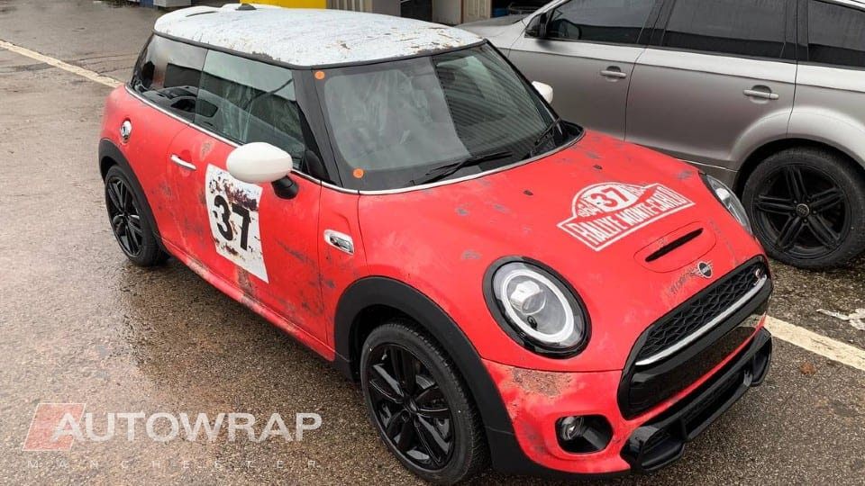 A mini cooper with a custom printed wrap designed to look like a retro rally car