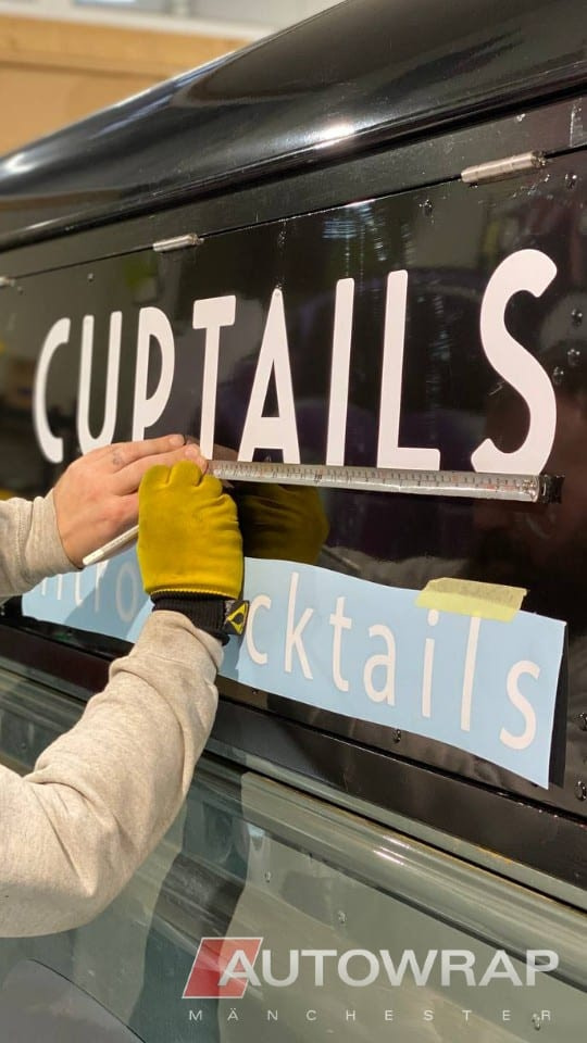 Signage for "Cuptails" being applied to a commercial vehicle